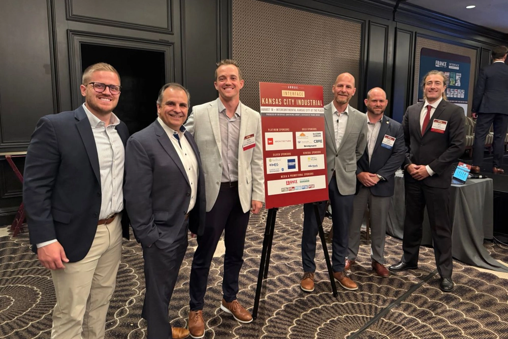 group of people in professional attire by a sign
